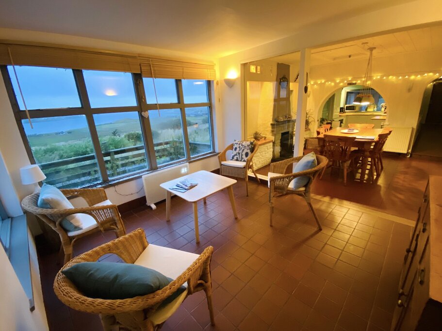 Open plan sunroom, dining room and kitchen.